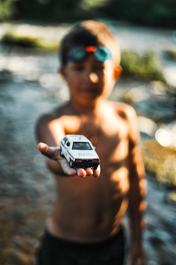 Shirtless boy showing toy car