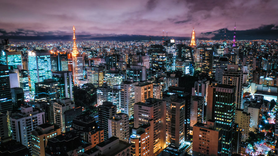 High angle view of illuminated cityscape against sky at night