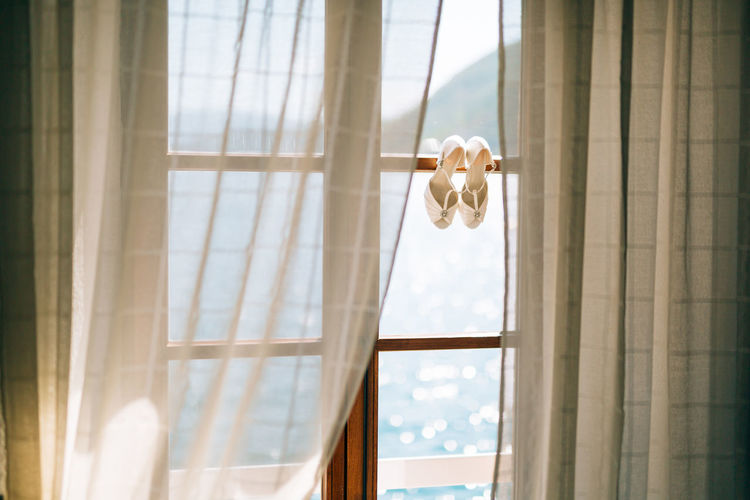 LOW ANGLE VIEW OF CURTAIN HANGING ON WINDOW