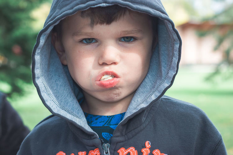 Close-up of portrait of boy eating food outdoors