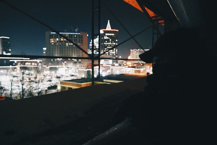 Rear view of man on illuminated city at night