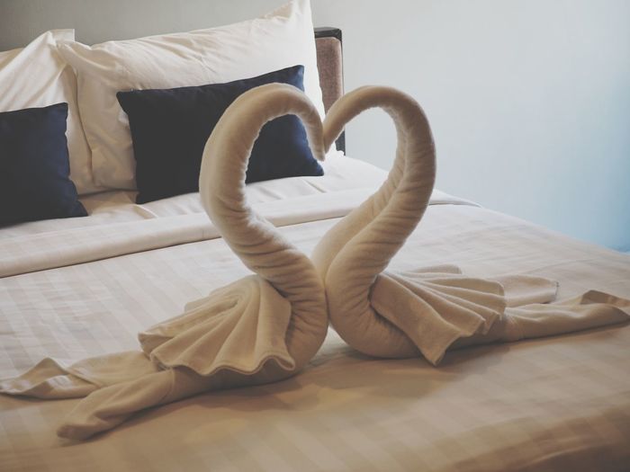 Swan shape towels on bed in hotel room