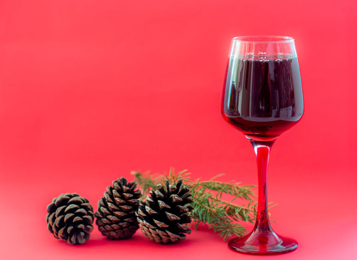 Close-up of wine glass against red background