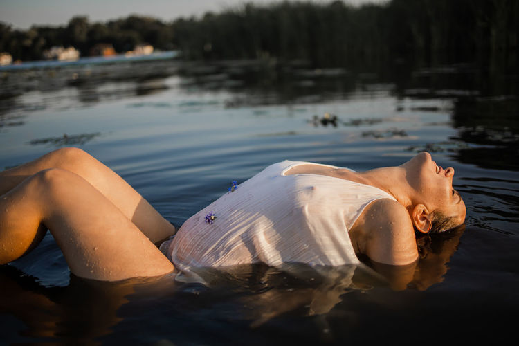 Low section of woman relaxing in lake