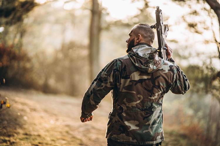 Midsection of man holding umbrella in forest
