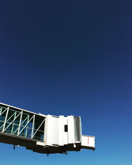 Low angle view of passenger boarding bridge against clear sky
