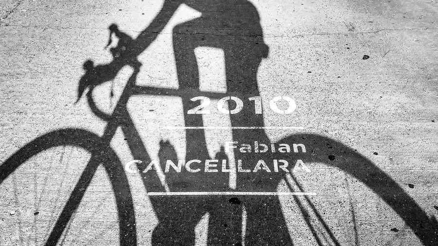 Shadow of people riding bicycle on street
