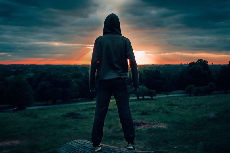 Man standing on field at sunset