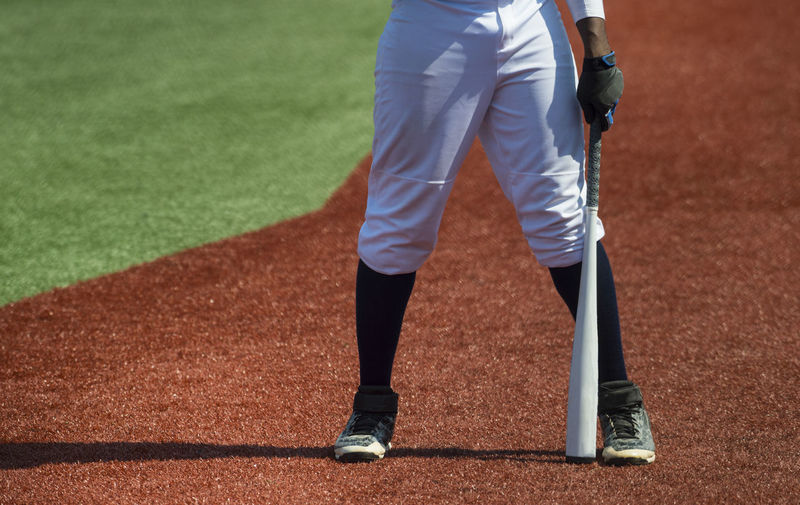 Low section of baseball player with bat on field