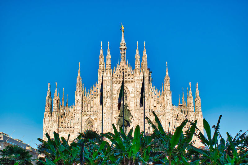 The golden sunshine is reflecting on the front of the magnificent duomo di milano or milan cathedral