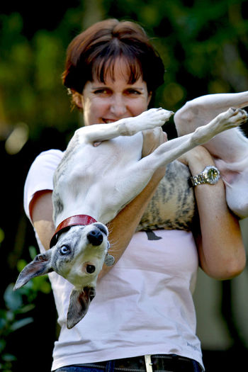 Portrait of smiling young woman carrying whippet