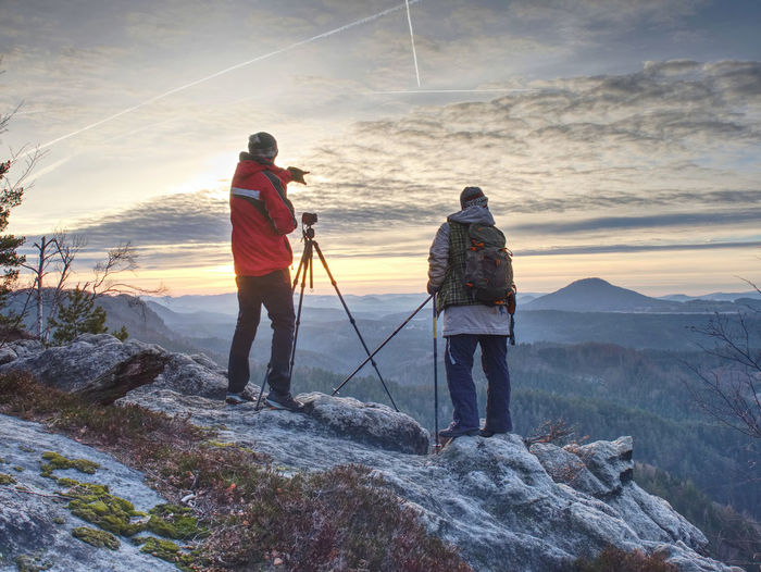 Nature travel photographers in red and light jacket taking photo of autumnal landscape