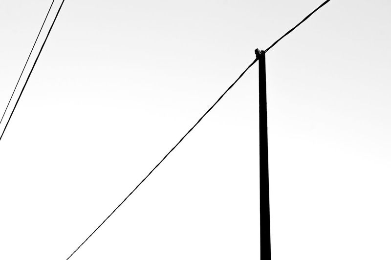 Low angle view of silhouette pole against clear sky