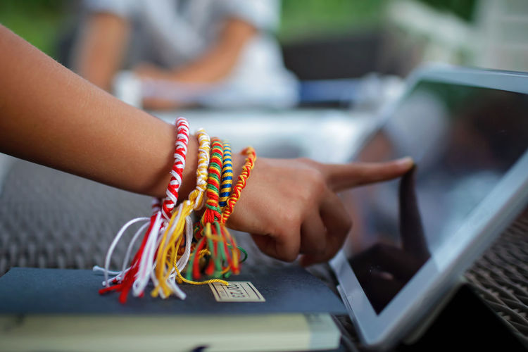 Hand with handmade bracelets touches laptop, digital small business, e-commerce. remote job