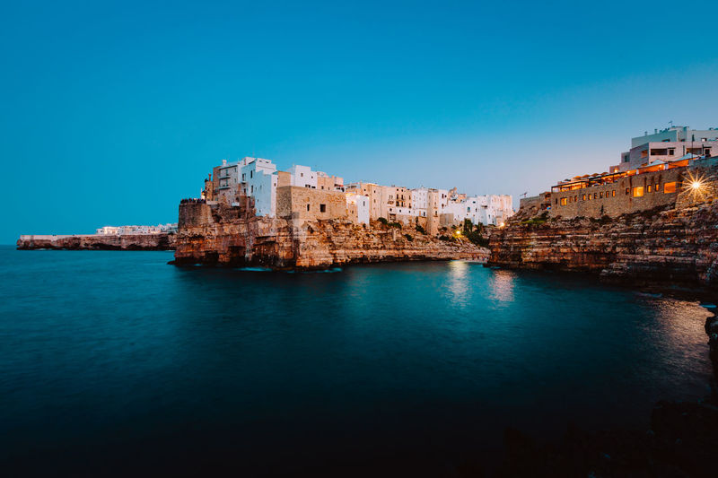 Polignano a mare at sunset, blue hour, seen from the panoramic point in front of the village