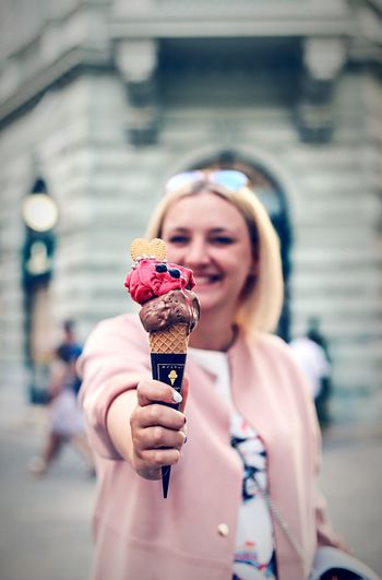 Woman holding ice cream in city