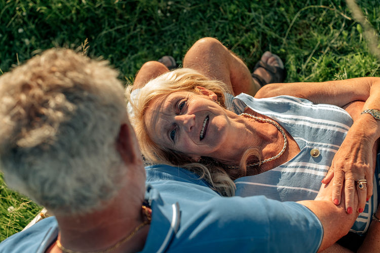 Top view of romantic senior couple - woman lying down on husband legs - elderly people bonding