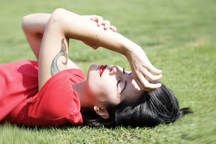 Midsection of woman lying on field