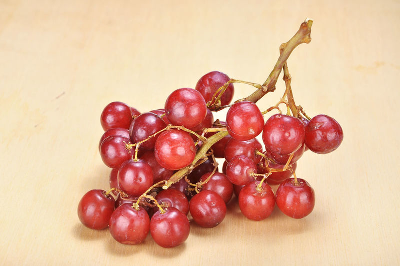 Close-up of red grapes on wooden table