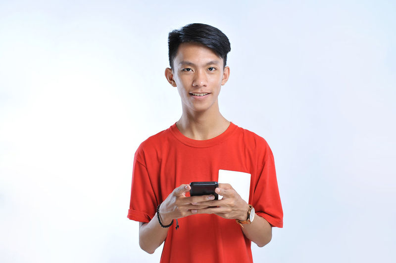 Potrait of young asian student playing a smartphone