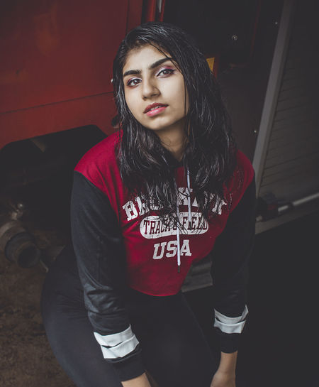 Portrait of young woman standing by fire engine outdoors
