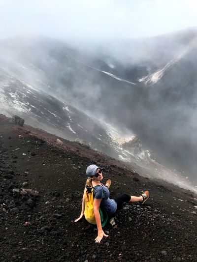 Woman sitting at volcanic crater