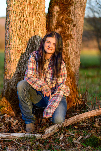 Portrait of young woman sitting on logs