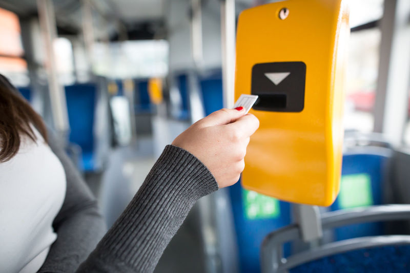 Close-up of hand holding mobile phone in bus