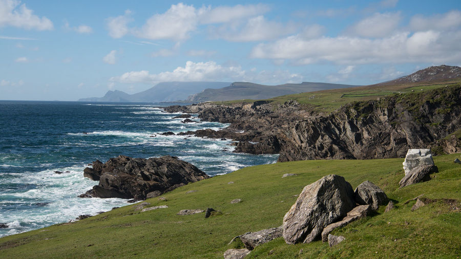 Scenic view of cliff by sea against sky
