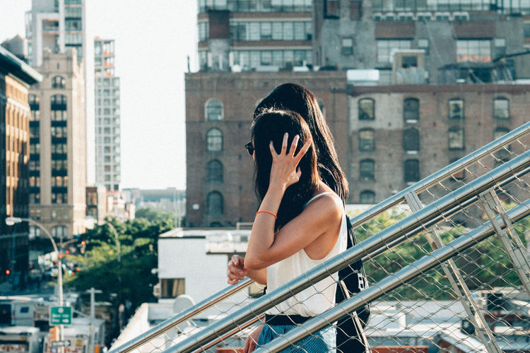 Women walking on staircase against buildings