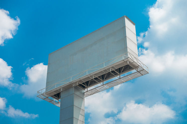 Low angle view of billboard against sky