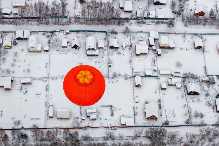 Aerial view of hot air balloon over snow covered field
