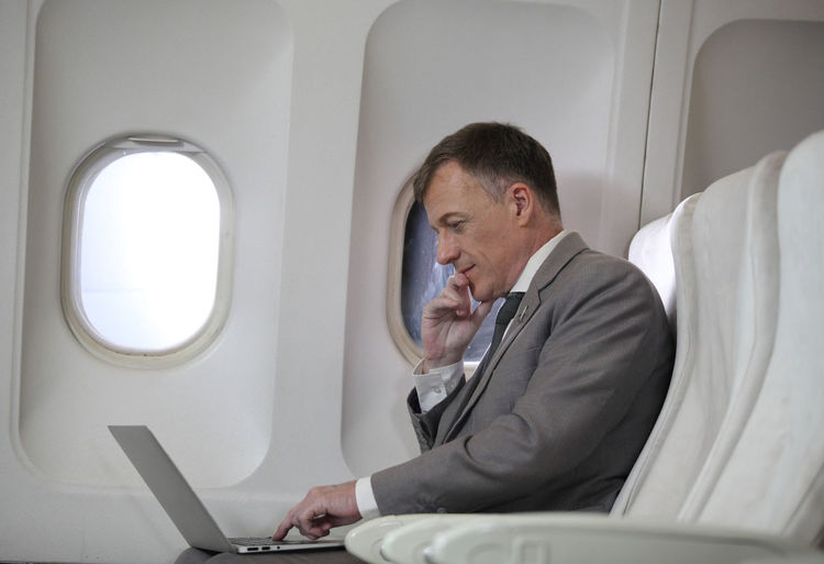 Man sitting in airplane window