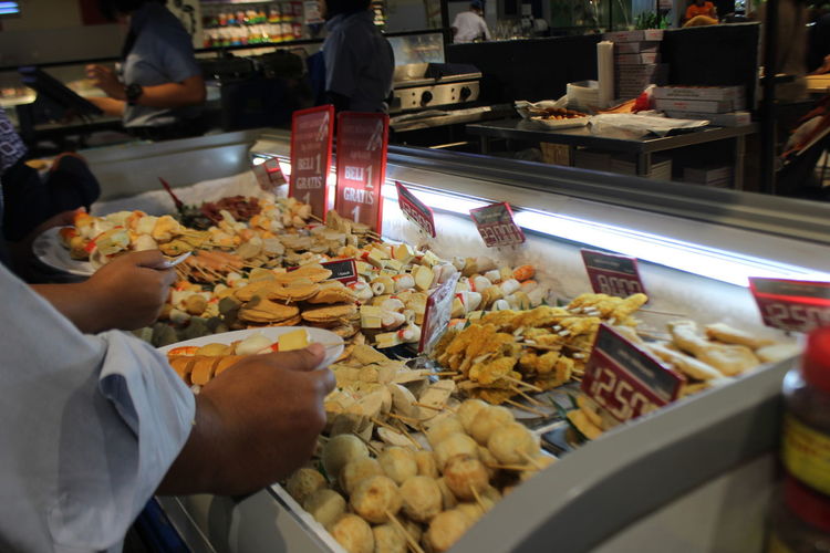 Cropped image of people working in food store