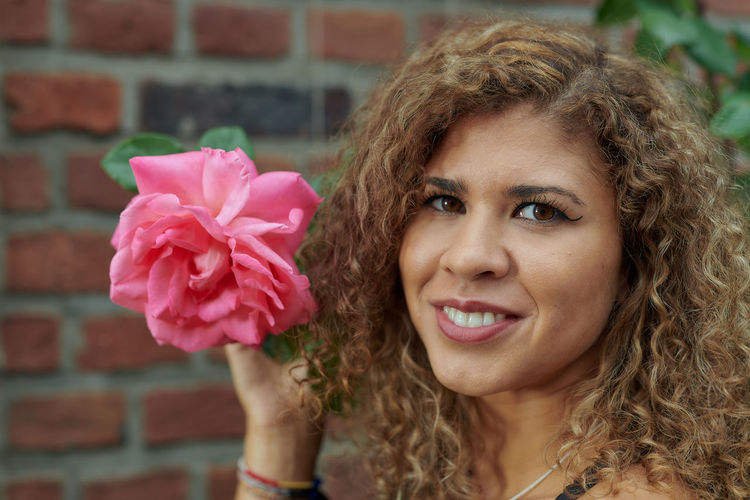 Portrait of smiling woman with pink flower