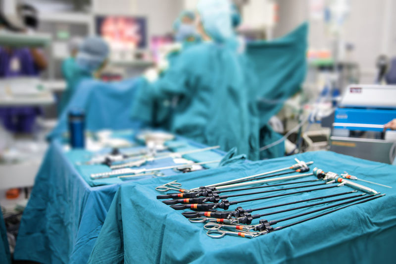 Close up of sterile table with laparoscopic tools in operating room, surgery team