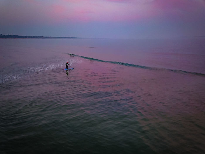 Lone surfer after pink sunset 