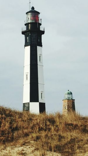 Lighthouse on hill against sky