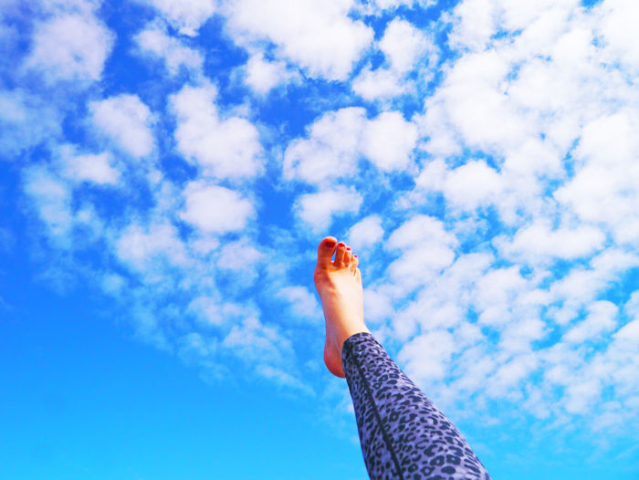 Low section of woman against blue sky