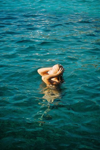 High angle view of woman swimming in sea. shot on kodak portra 800 35mm film. 