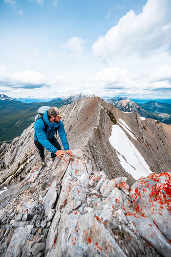 Mountain runner scrambling up mountain ridge in canadian rockies