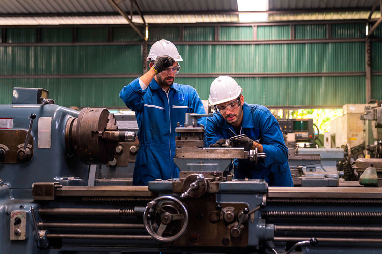 Men repairing machinery in factory