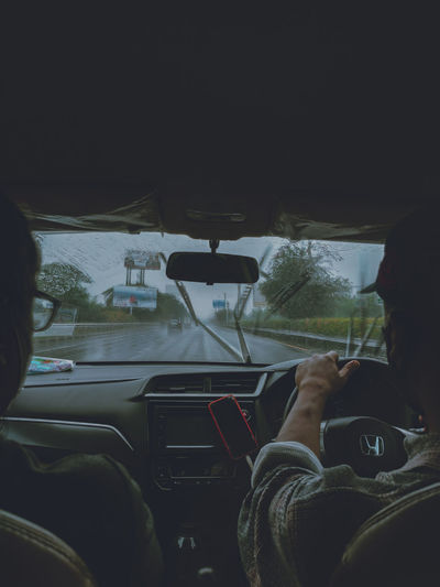 Rear view of man seen through car windshield