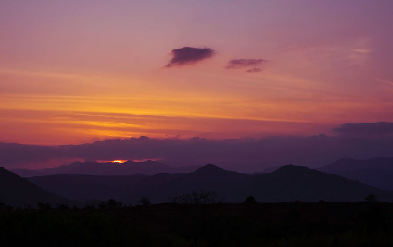 Scenic view of silhouette mountains against sky during sunset