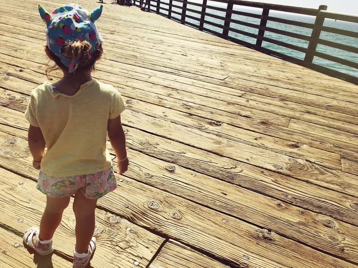 Full length of a girl standing on wooden footbridge