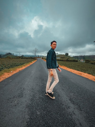 Full length of man standing on road against sky