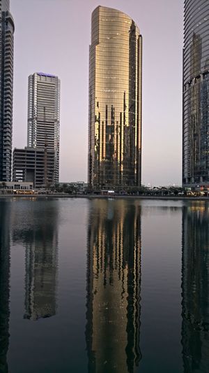 Reflection of buildings in city against sky