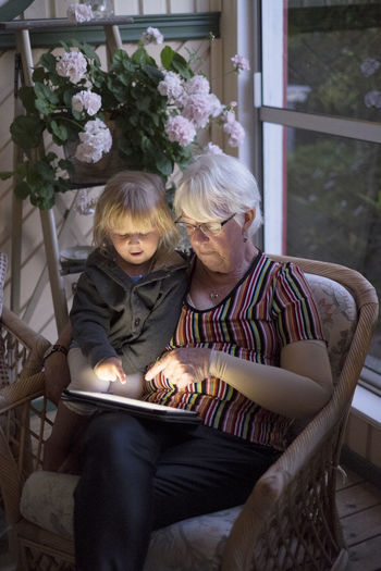 Grandmother with granddaughter using digital tablet