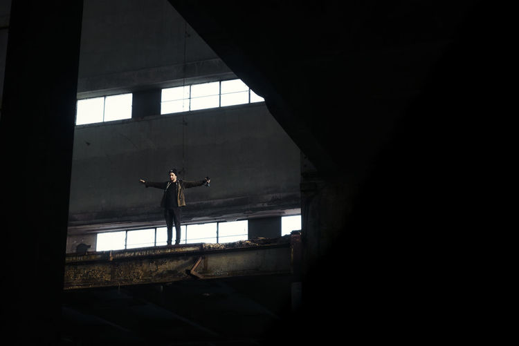 Low angle view of man standing in abandoned building