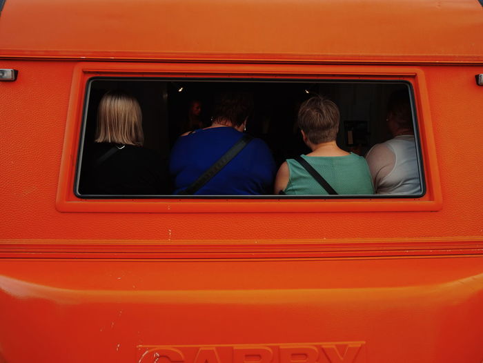 Women seen through rear windshield of vehicle
